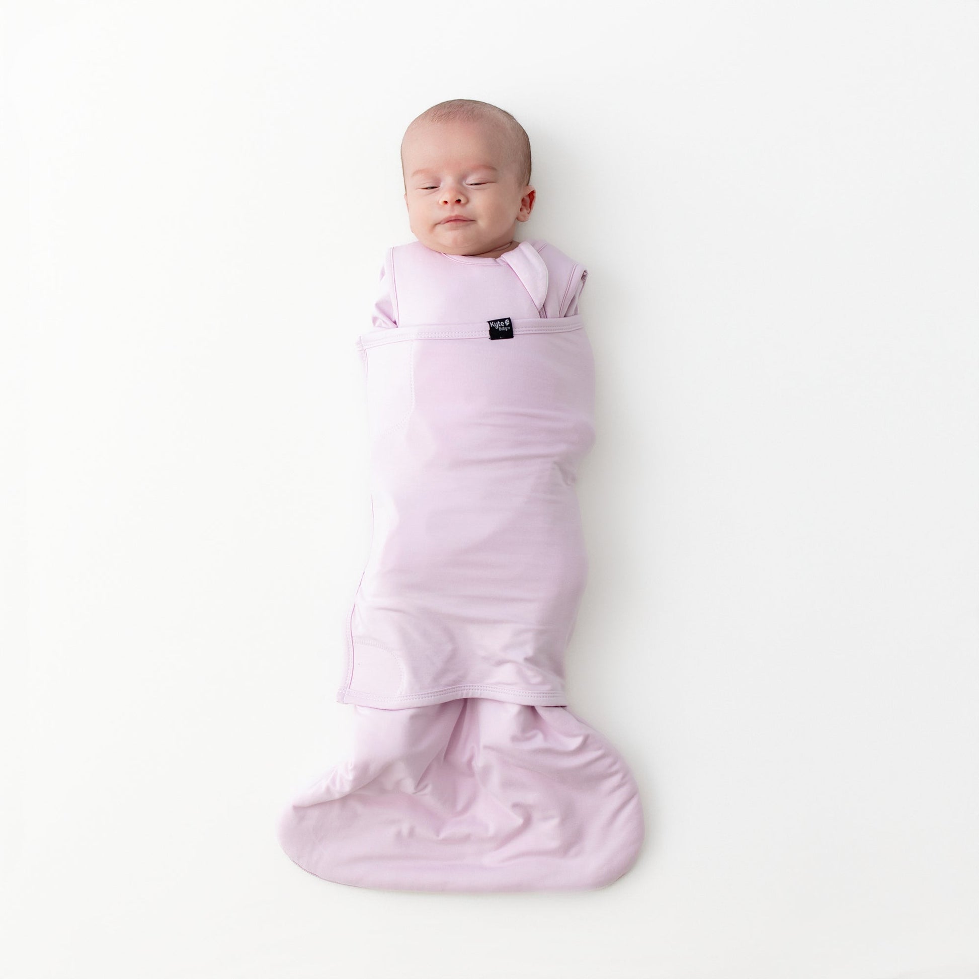 Sleeping newborn swaddled in the Sleep Bag Swaddler in Thistle 1.0